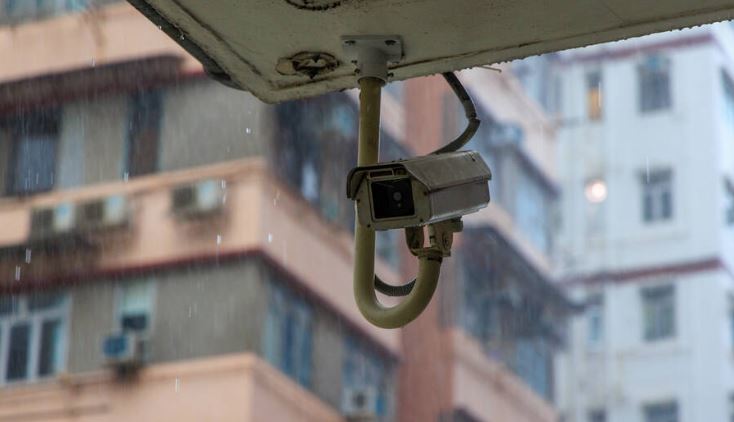 Security surveillance camera on high-rise apartment building in rain